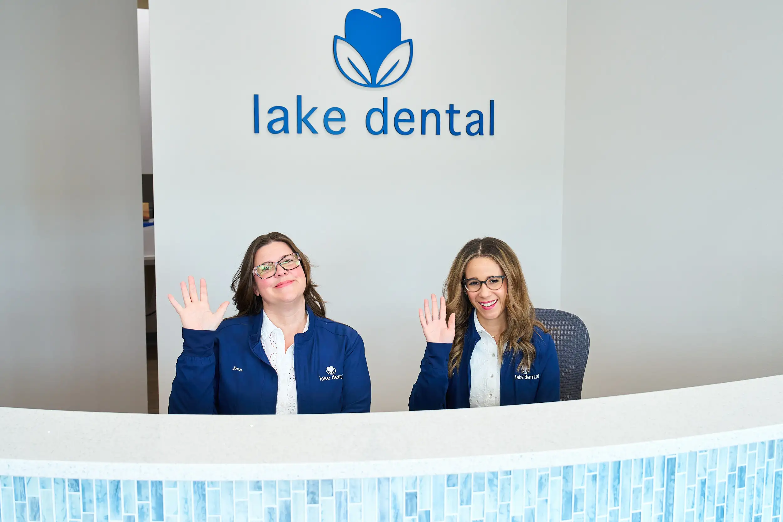 A patient being welcomed at the Lake Dental reception desk